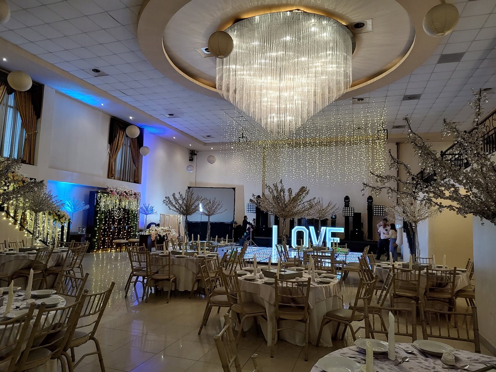 Salón VillaMont con candelabro de cristal, mesas vestidas y letras LOVE iluminadas